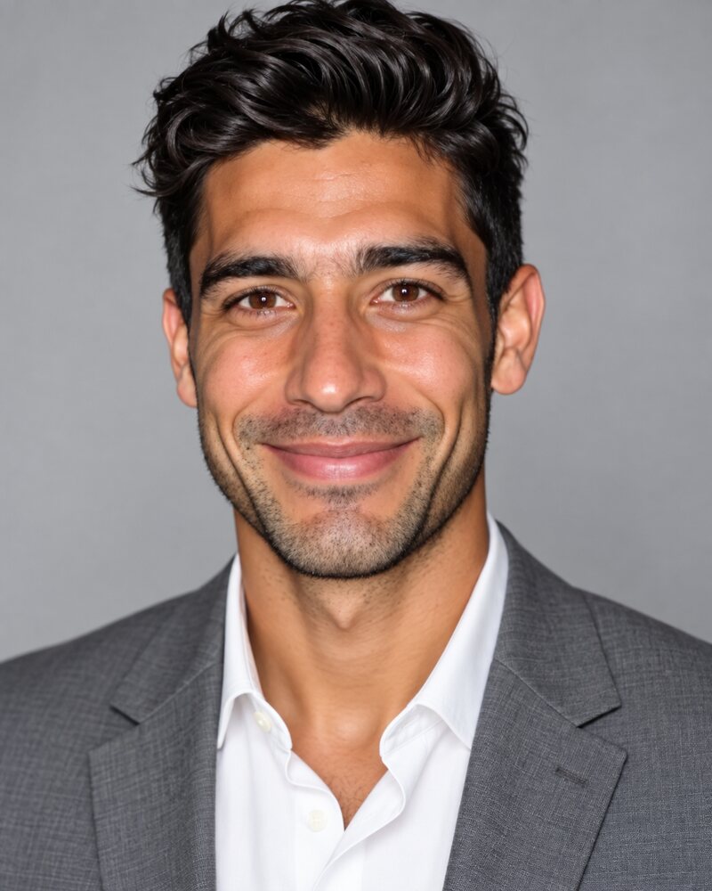The same man in a grey blazer that fits, shoulder seams at the edge of his shoulders and the shirt collar sitting flat