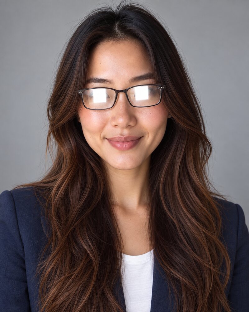 Woman wearing glasses with bright white reflections across both lenses that hide her eyes