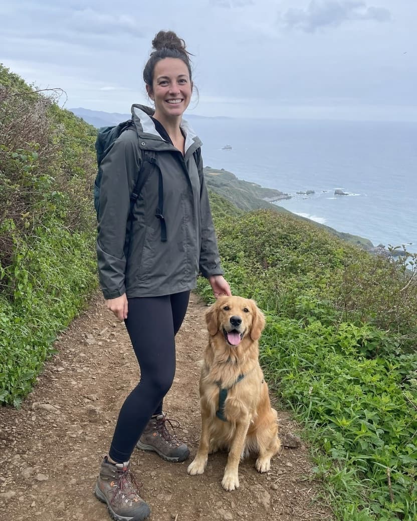 Woman hiking a coastal trail with a golden retriever, an example Bumble photo
