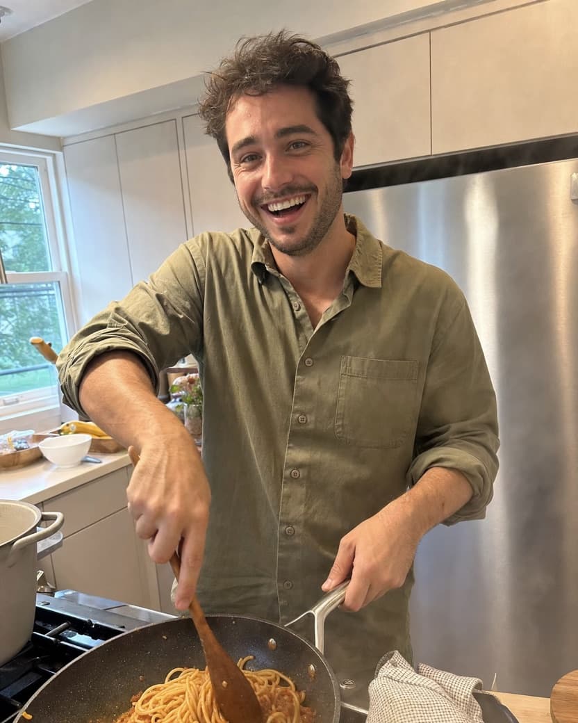Man laughing while cooking in a bright kitchen, an example Hinge photo